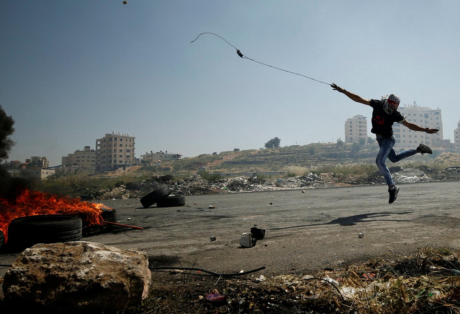 Palestinski prosvjednik baca kamenje na izraelske trupe tijekom nereda na prosvjedu podrške palestinskim zatvorenicima koji štrajkaju glađu kod Ramale.