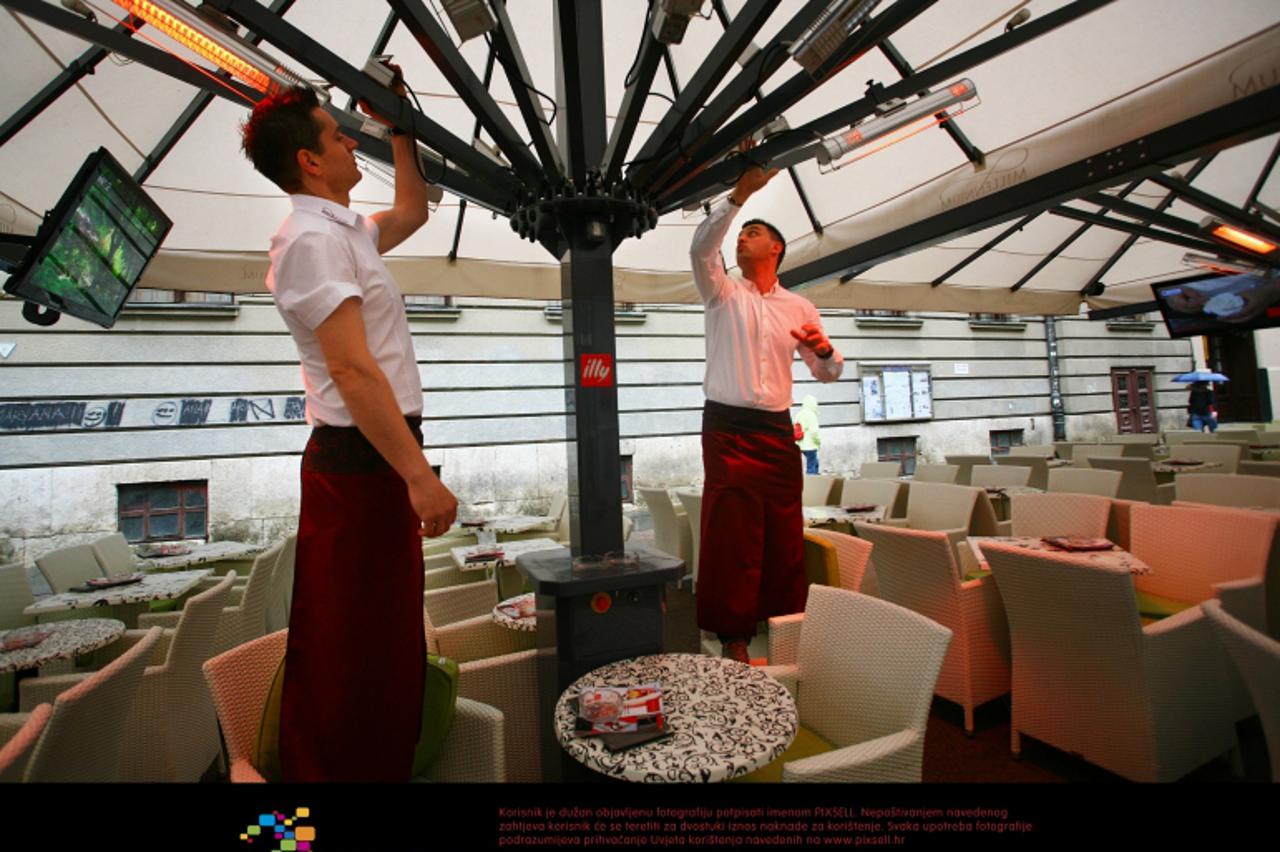 '28.05.2011., Zagreb -  Nakon dugog razdoblja vrucina i suncanog vremena u na Zagreb se spustila kisa uz osjetno zahladjenje. Zbog niskih temperatura konobari u na terasama kafica u Bogovicevoj ulisi 