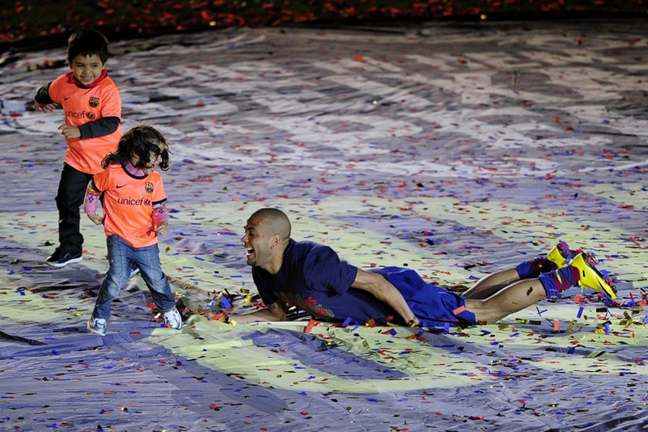 'Barcelona\'s Brazilian defender Daniel Alves celebrates after winning the Spanish La Liga title at Camp Nou stadium in Barcelona on May 16, 2010. Barcelona retained the Spanish La Liga title on the f