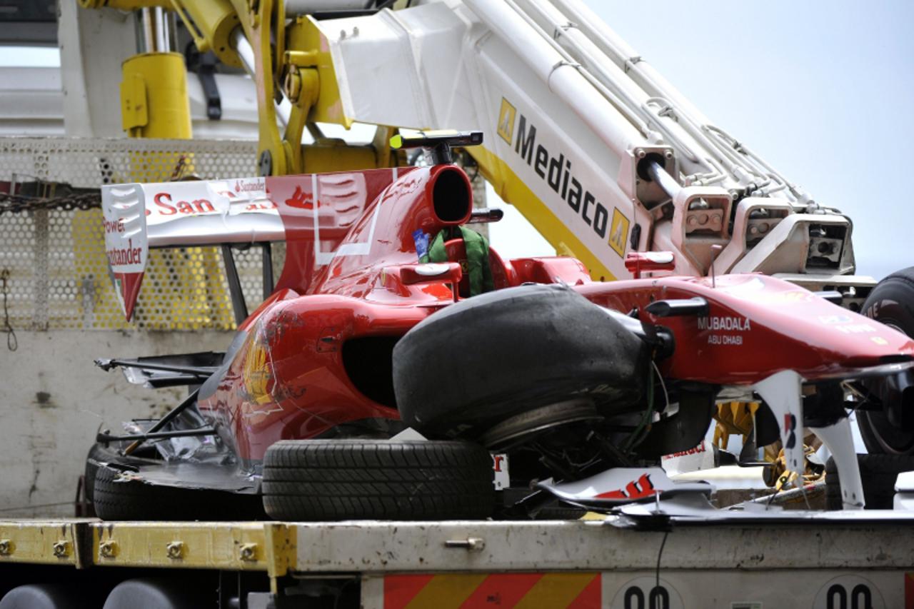 'A truck carries the damaged car of Ferrari\'s Spanish driver Fernando Alonso after he crashed at the Monaco street circuit on May 15, 2010, during the third free practice session of the Monaco Formul
