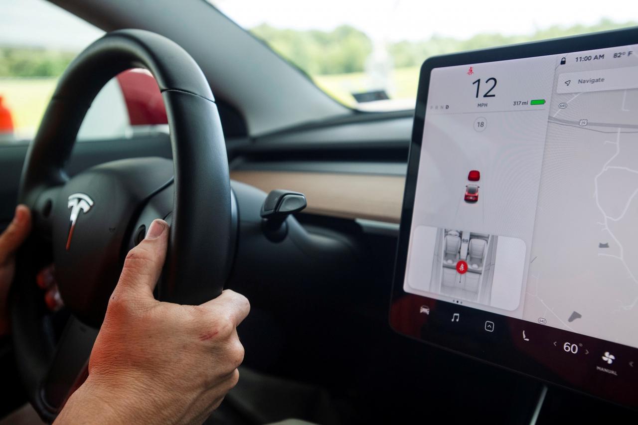 FILE PHOTO: IIHS media relations associate Young demonstrates front crash prevention test on Tesla Model 3 at IIHS-HLDI Vehicle Research Center in Ruckersville, Virginia