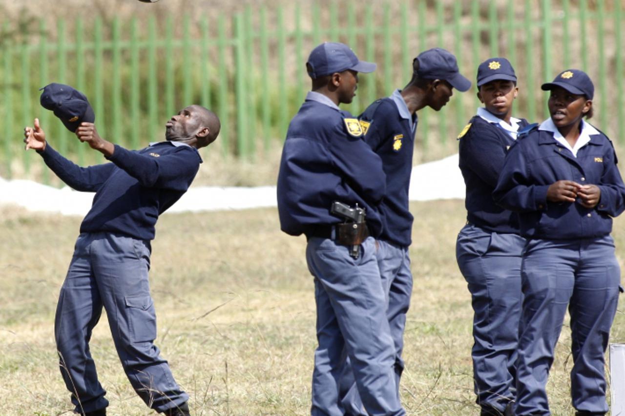 'A police officer plays with a soccer ball during a Dreamfields project in Orange Farm township, south of Johannesburg , May 8,2010. The Dreamfields project aims at developing soccer facilities in tow