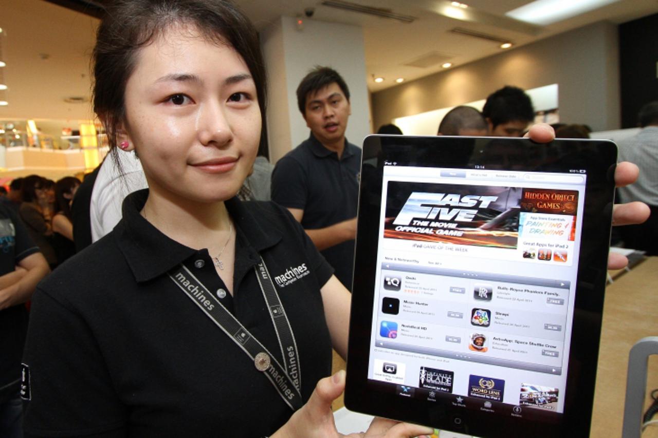 'A Malaysian shopkeeper poses the newly released Apple iPad 2 at an Apple store in Kuala Lumpur on April 29, 2011.  The iPad 2 went on sale in many countries across Asia and beyond as Apple\'s updated