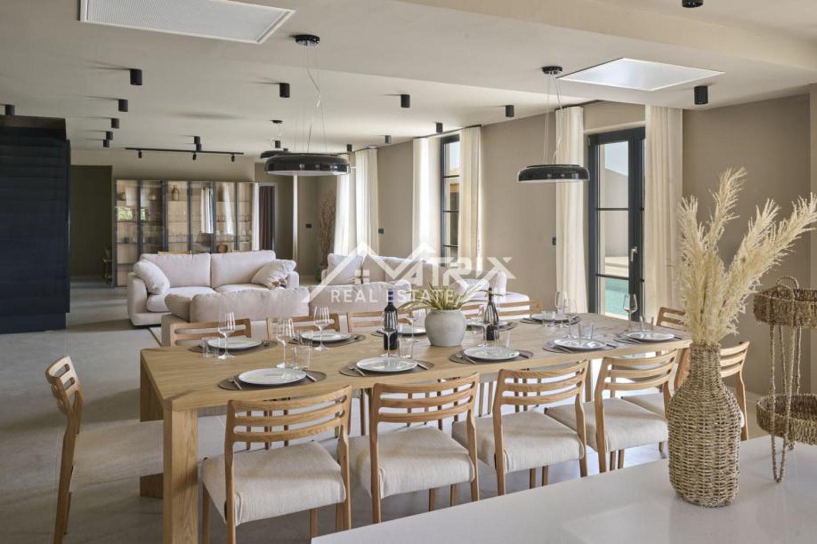 U prizemlju se nalazi prostrani open space koji povezuje moderno uređenu kuhinju, blagovaonicu i dnevni boravak s izlazom na terasu i bazen. 