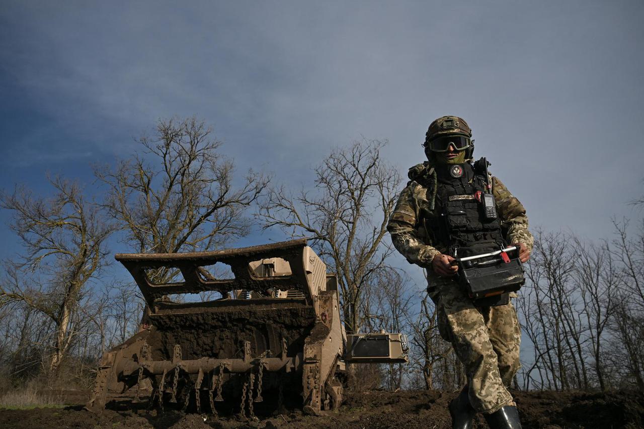 Ukrainian military sapper uses a demining machine during clearance an agricultural field in Kherson region
