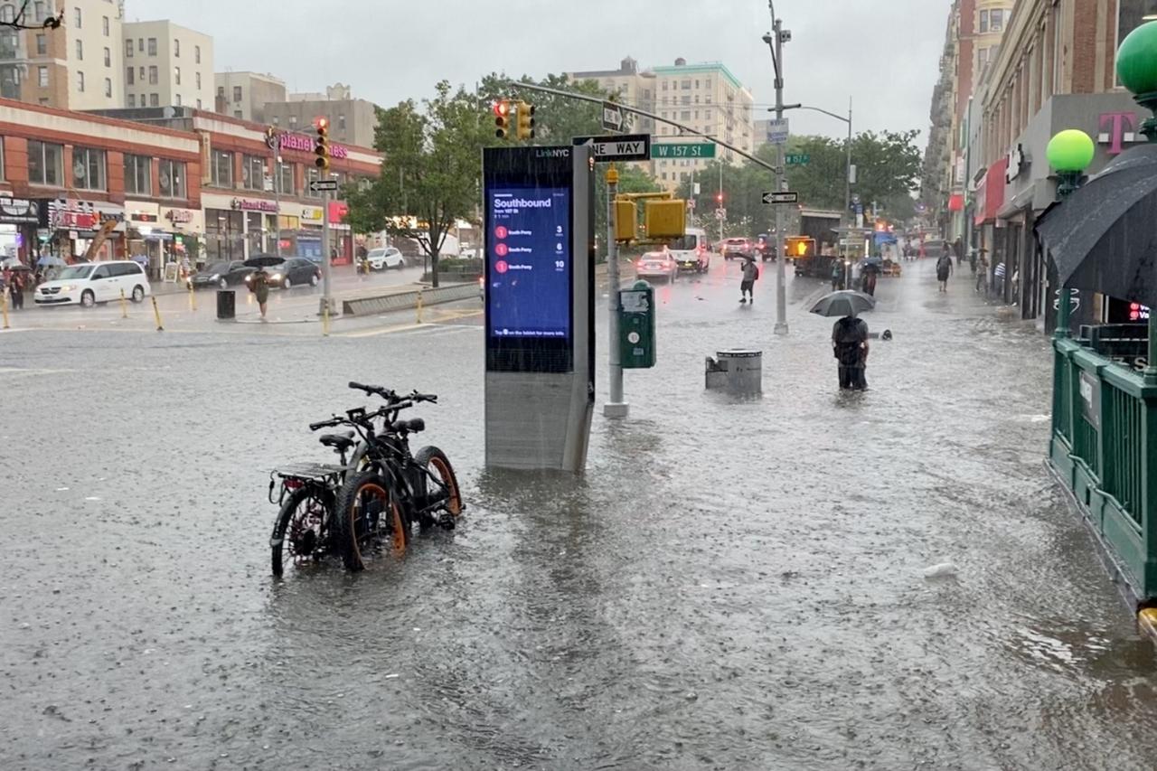 A person wades through the flood water near the 157th St. metro station in New York