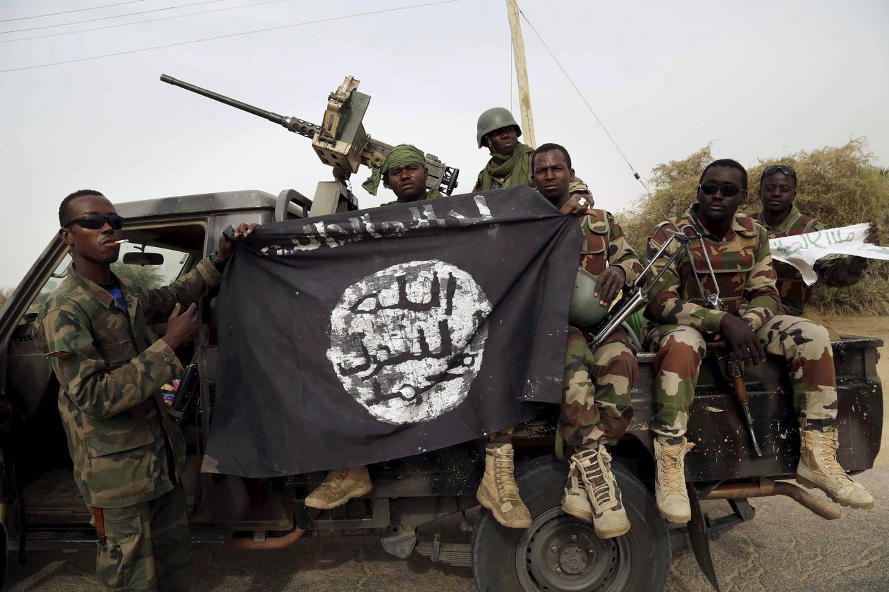 Nigerien soldiers hold up a Boko Haram flag that they had seized in the recently retaken town of Damasak, Nigeria, March 18, 2015. Chadian and Nigerien soldiers took the town from Boko Haram militants earlier this week. The Nigerian army said on Tuesday i