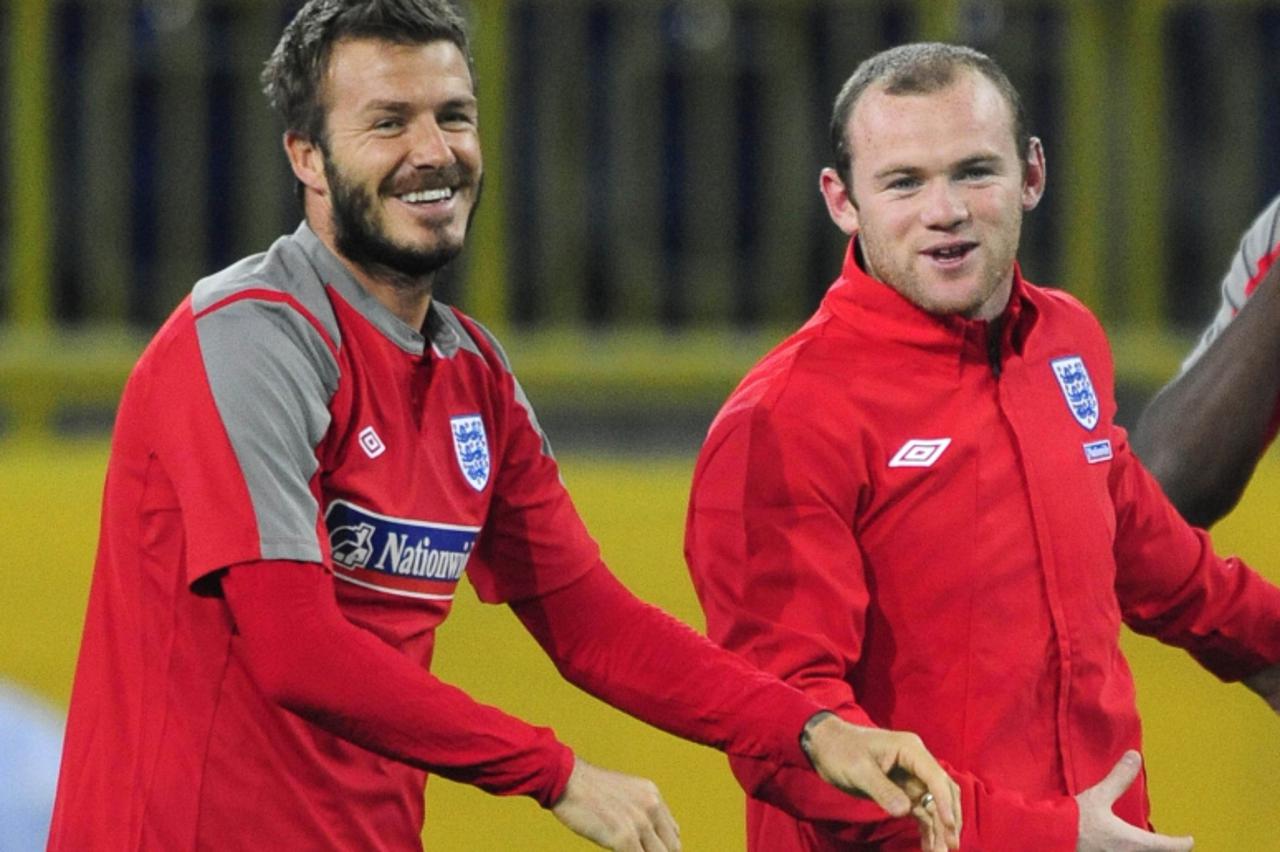 'England\'s David Beckham (L) and Wayne Rooney warm up during a training session at the Dnipro Arena in Dnepropetrovsk October 9, 2009. England play Ukraine in their World Cup 2010 qualifying soccer m