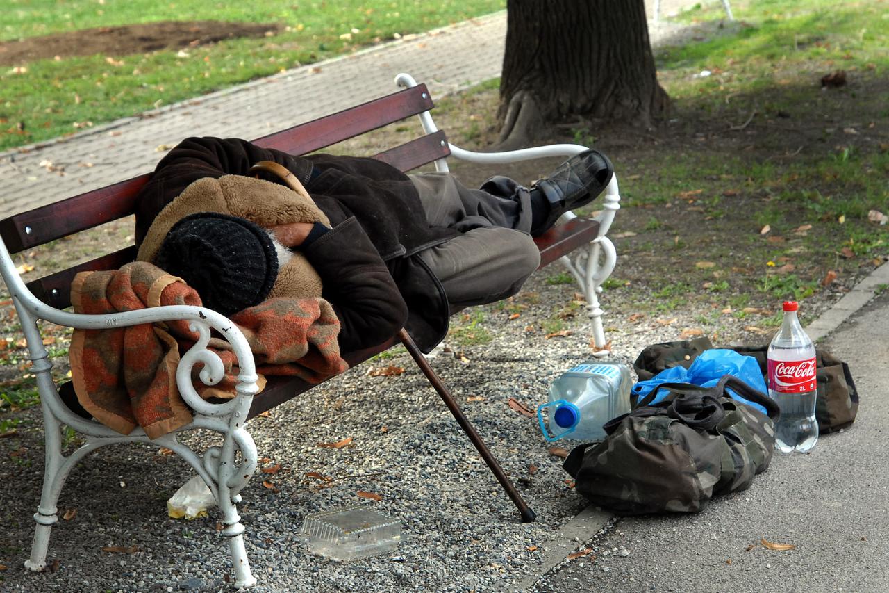 08.10.2012., Slavonski Brod - Starac beskucnik spava na klupi u parku. Zbog hladnoce ogrnuo se kaputom, a dekicu je stavio pod glavu. Uz njega na zemlji, u dvije torbe stoje njegove stvari i boca vode.  Photo: Ivica Galovic/PIXSELL
