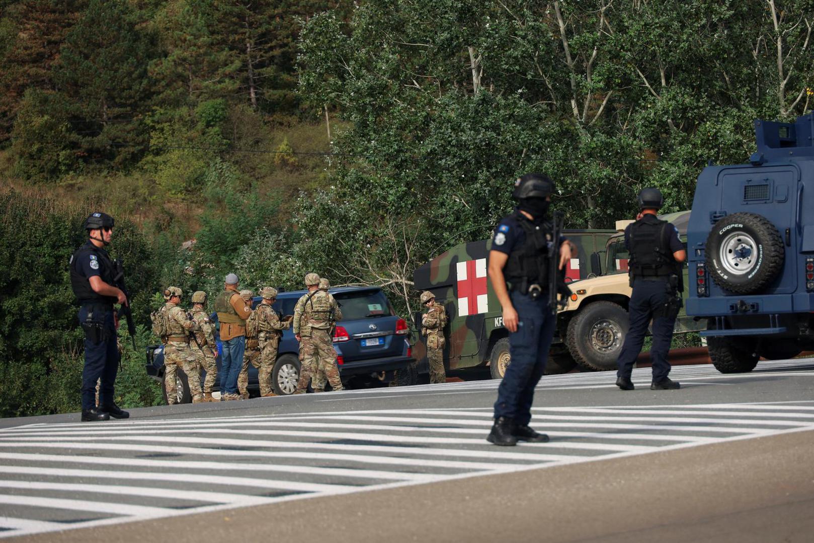 People work as Kosovo police and U.S. and EU troops stand by after one police officer was killed, another hurt in Kosovo gunfire, in Josevik, Kosovo September 24, 2023. REUTERS/Fatos Bytyci Photo: FATOS BYTYCI/REUTERS