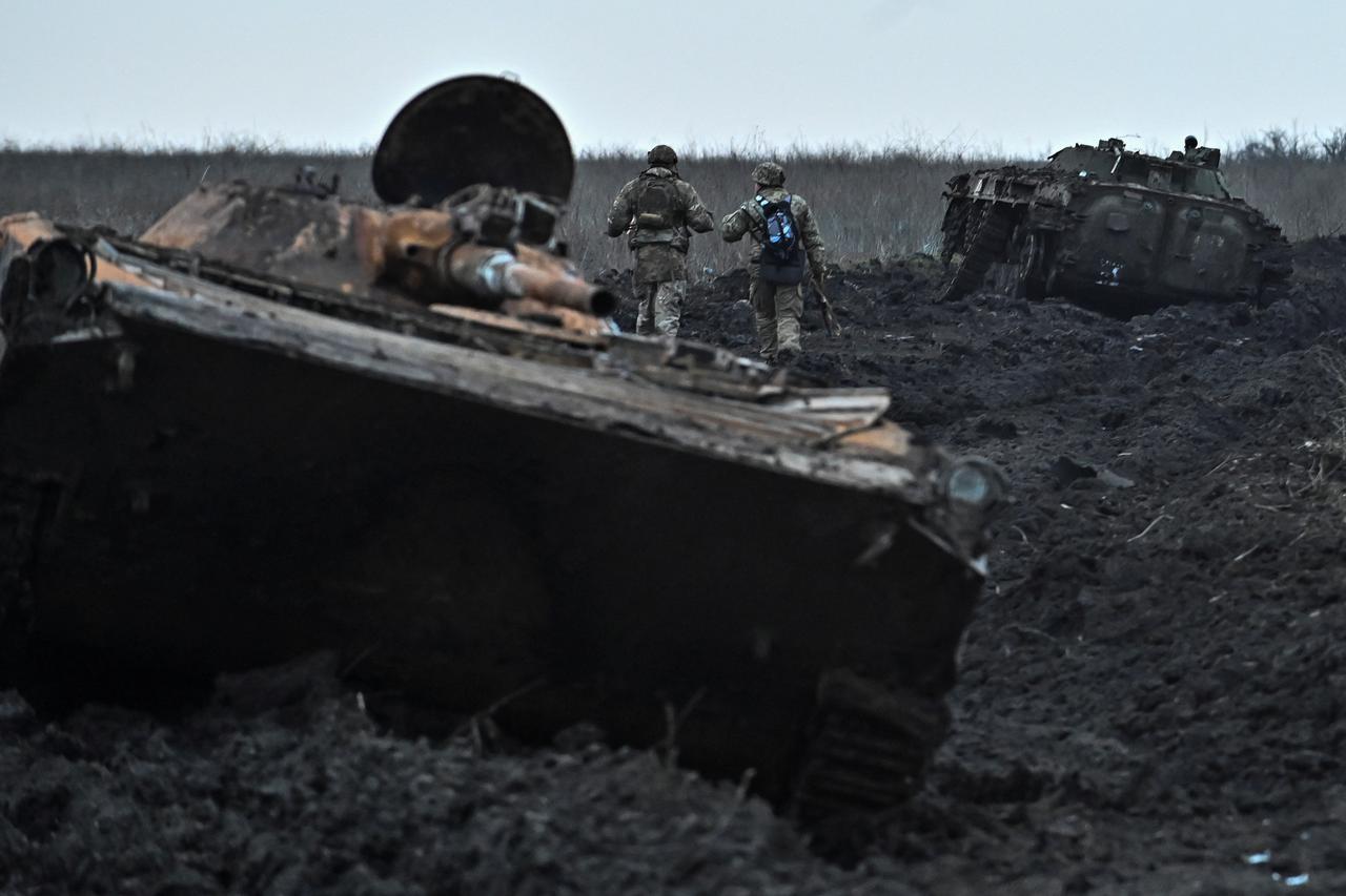 Ukrainian servicemen walk past abandoned armoured fighting vehicles near the front-line village of Robotyne in the Zaporizhzhia region