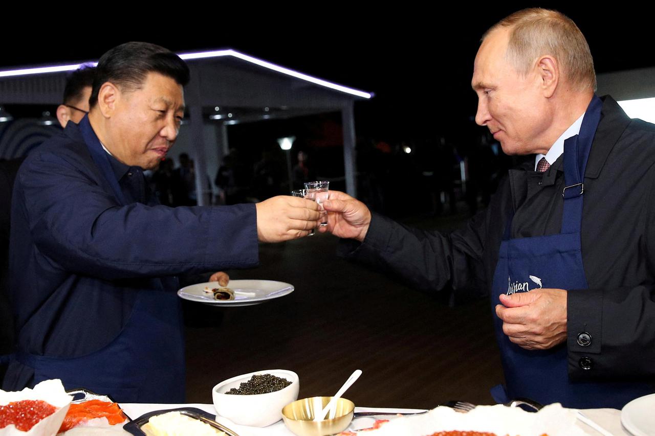FILE PHOTO: Russian President Vladimir Putin and Chinese President Xi Jinping toast during a visit to the Far East Street exhibition on the sidelines of the Eastern Economic Forum in Vladivostok