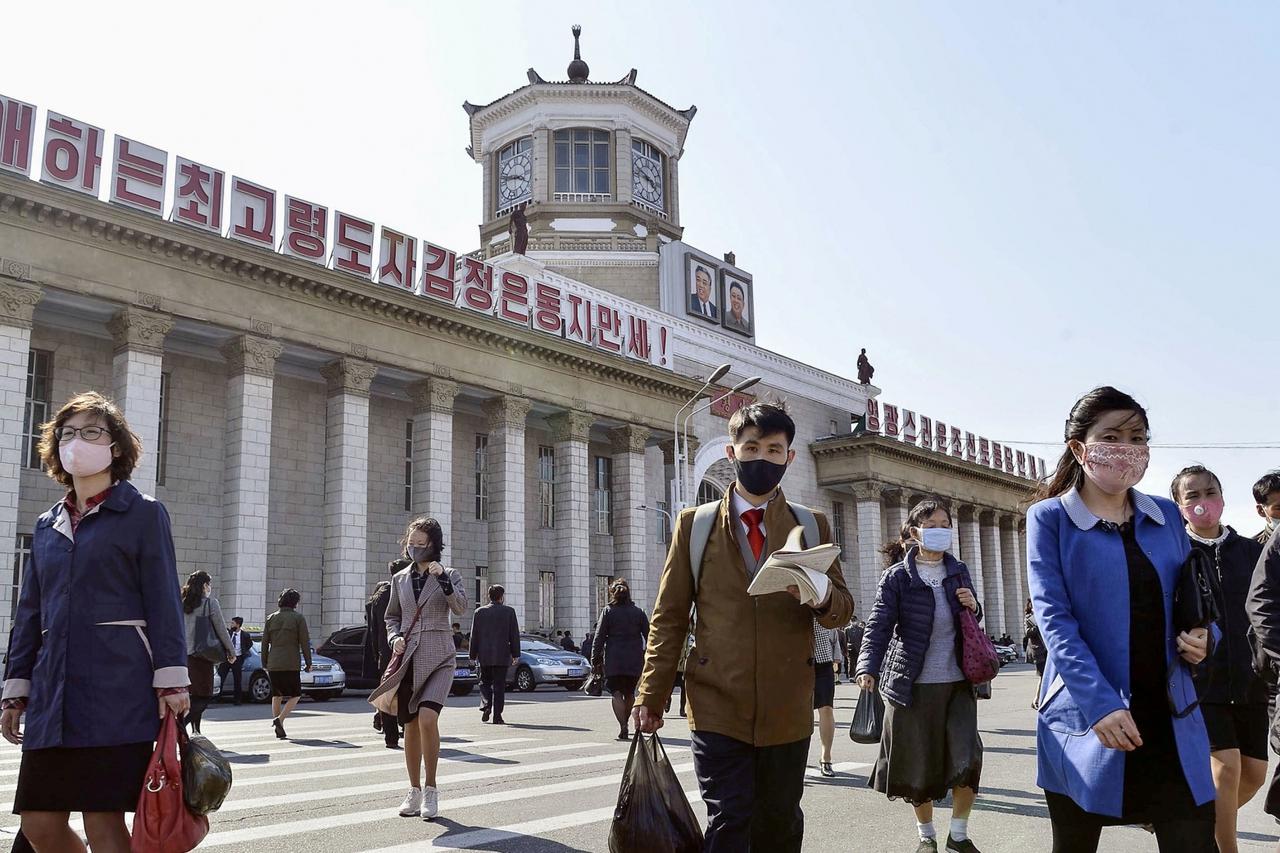 FILE PHOTO: People wearing protective face masks walk amid concerns over the coronavirus disease (COVID-19) in front of Pyongyang Station in Pyongyang, North Korea