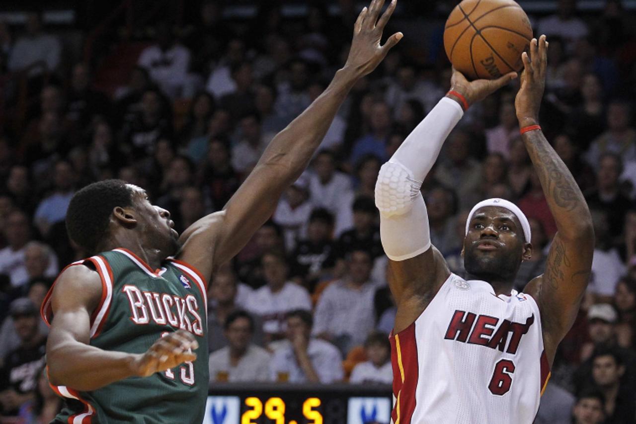 'Milwaukee Bucks\' Ekpe Udoh (L) leans in as Miami Heat\'s LeBron James shoots, in the first half of their NBA basketball game in Miami, Florida November 21, 2012. REUTERS/Andrew Innerarity (UNITED ST