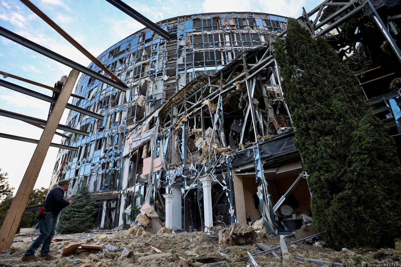 Man stands next to a business and entertainment centre heavily damaged by a Russian military strike in Kharkiv