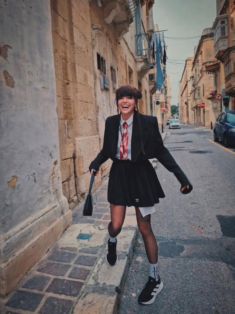 U središtu pozornosti našla se njezina odjevna kombinacija, provokativno izdanje koje stilski podsjeća na školsku uniformu, ali s odvažnim pomakom. Kratka suknja i bijela košulja upotpunjene su halterima, detaljem koji je cijelom izgledu dao "vamp" notu.