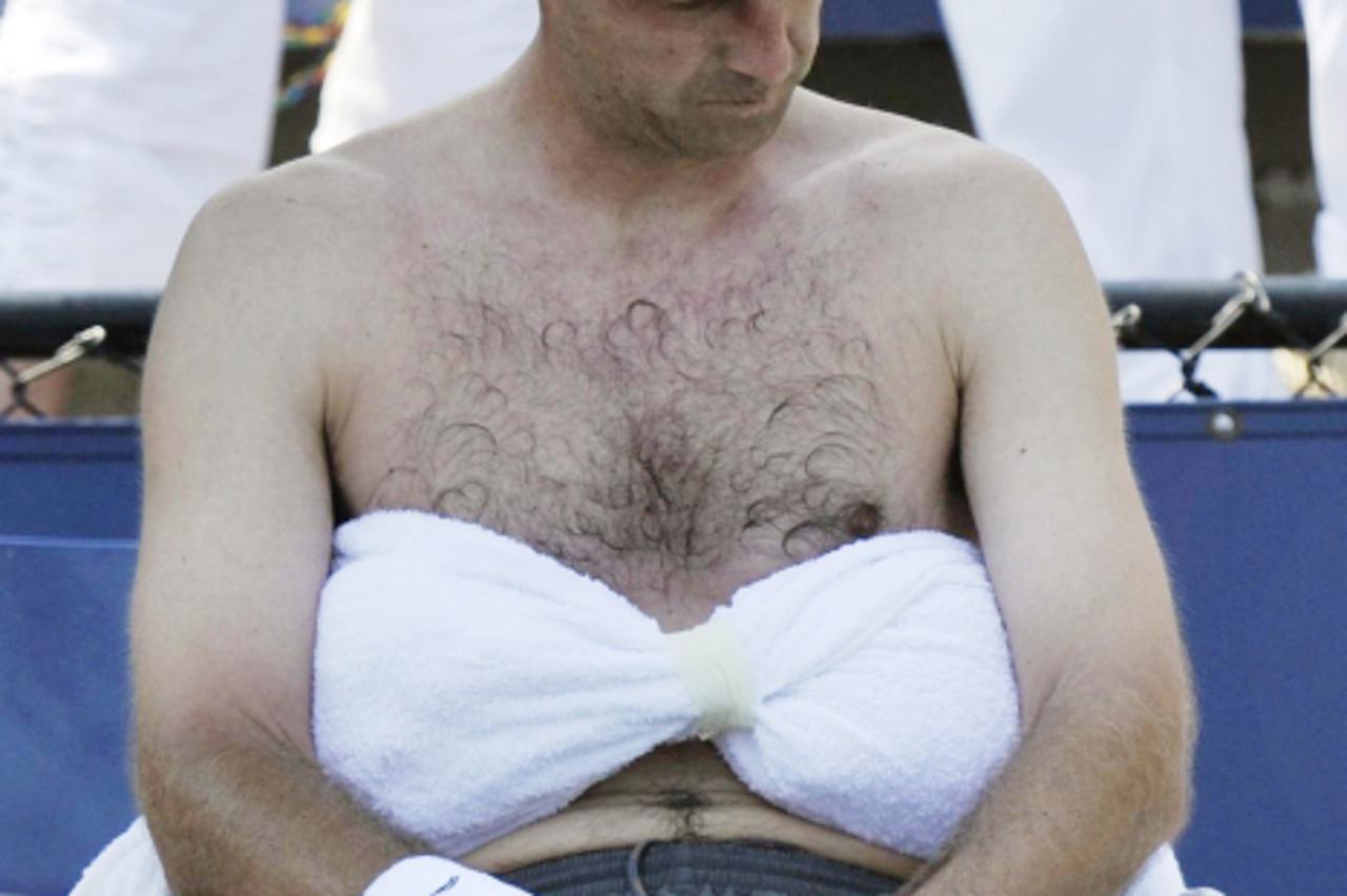 'Ivan Ljubicic of Croatia sits with ice packs on his stomach during a break against Ryan Harrison of the U.S. at the U.S. Open tennis tournament in New York, September 1, 2010. REUTERS/Ray Stubblebine