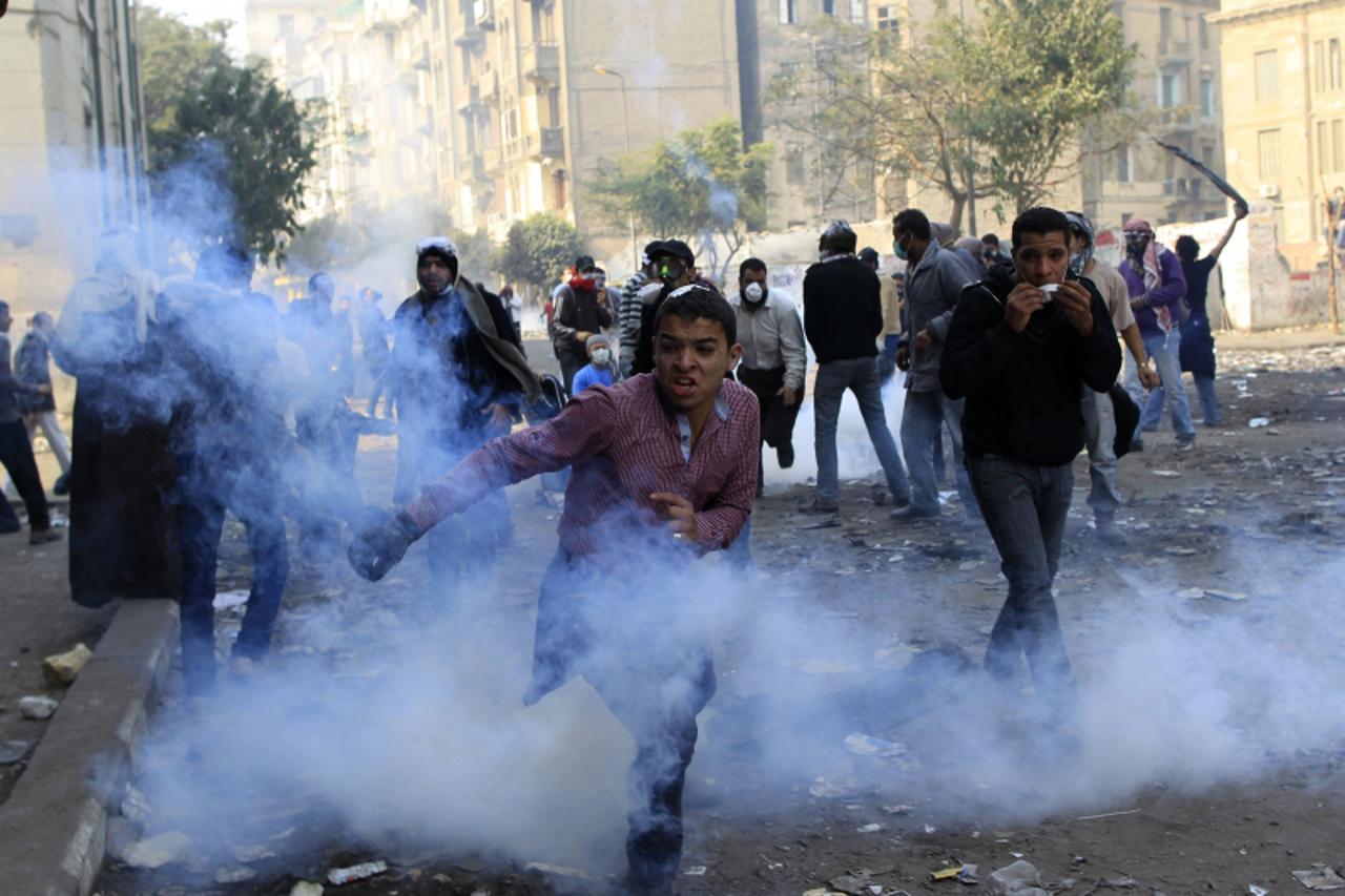 'Egyptian protesters clash with riot police along a road that leads to the Interior Ministry, near Tahrir Square in Cairo November 23, 2011. Street clashes rumbled on in Cairo on Wednesday as proteste