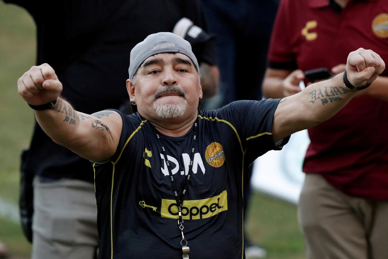 Diego Maradona smokes a cigar with former Reuters Cuba correspondent Andrew Cawthorne in Havana