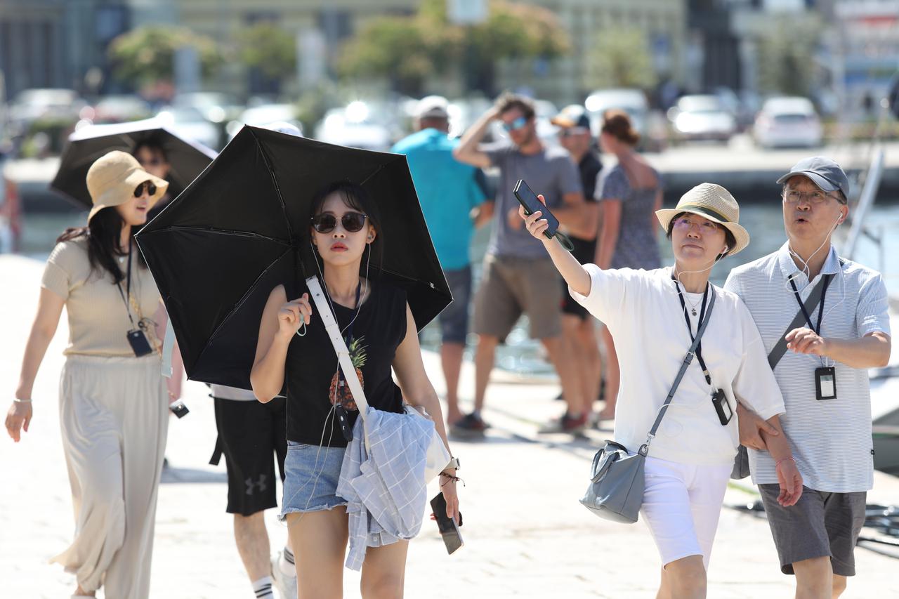 Šibenik: Turisti se štite kišobranima kako bi razgledali grad