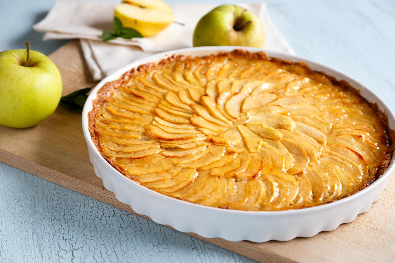 Tart od jabuka: Tart od jabuka elegantan je i ukusan desert koji spaja sočne jabuke i hrskavo tijesto u savršenoj harmoniji okusa. Svaki zalogaj nudi nježnu slatkoću jabuka, lagano začinjenu cimetom ili drugim začinima, uz profinjenu teksturu tijesta koja se topi u ustima. Tart je idealan za posebne prilike ili jednostavno uživanje uz šalicu čaja ili kave jer se brzo priprema, a svojom ljepotom i aromom uvijek ostavlja dojam. Za posluživanje, izvadite tart iz pećnice i ostavite ga oko sat vremena da se malo ohladi, zatim pažljivo uklonite obruč. Pospite cijeli tart šećerom u prahu i odmah ga poslužite.