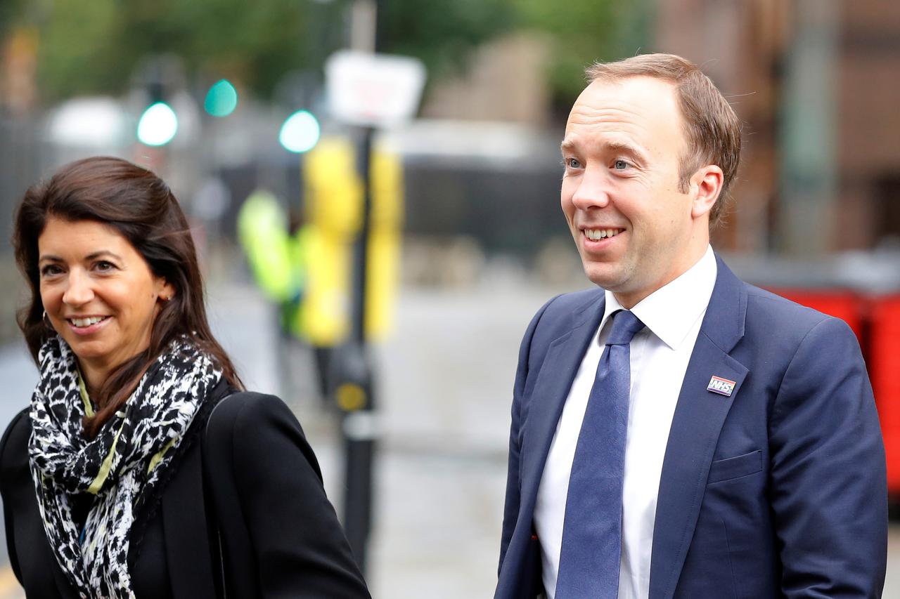 Britain's Secretary of State for Health Hancock walks with aide Coladangelo in Manchester