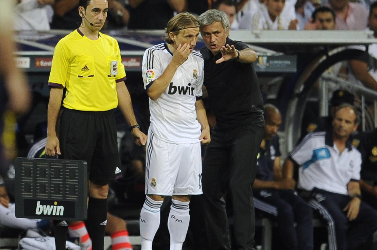 'Real Madrid's Croatian midfielder Luka Modric (C) listens to his coach Jose Mourinho (R) during the second leg of the Spanish Supercup football match Real Madrid CF vs FC Barcelona on August 29, 201