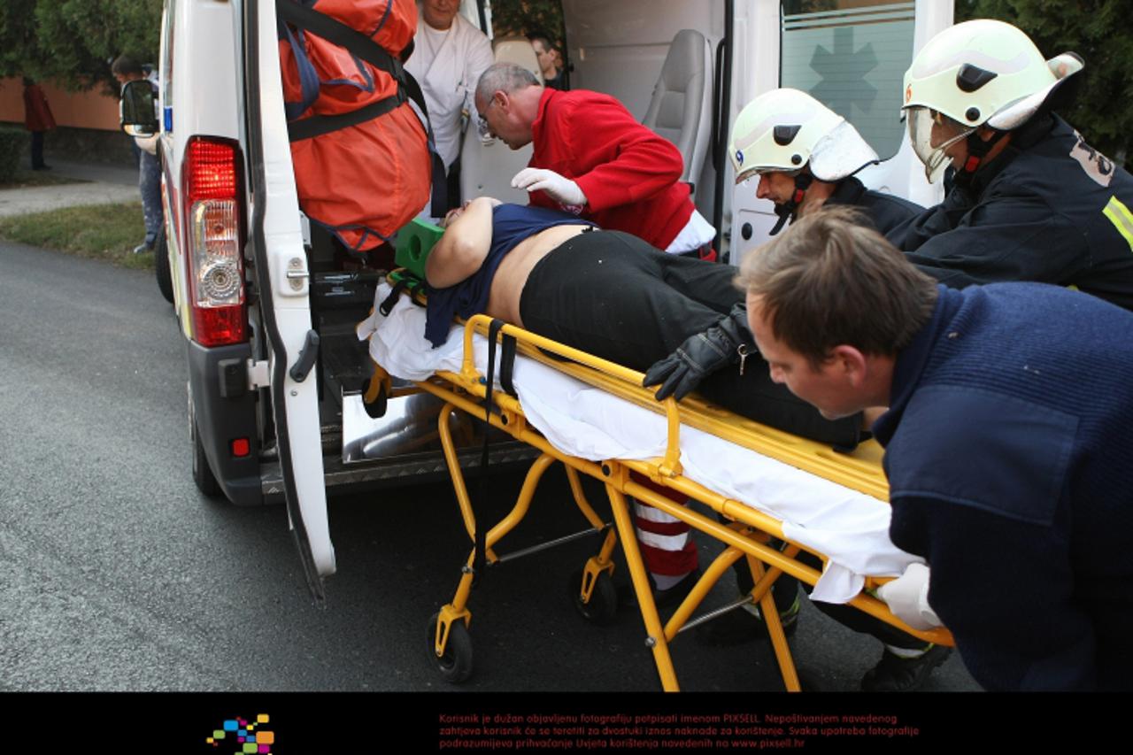 '30.10.2011., Osijek - Prometna nesreca nakon koje je osobni automobil Mazda 626 udarila u drvo i u kucu. Vatrogasci i hitna pomoc pokusavaju ozljedjenu zenu izvaditi iz auta. Photo: Davor Javorovic/P