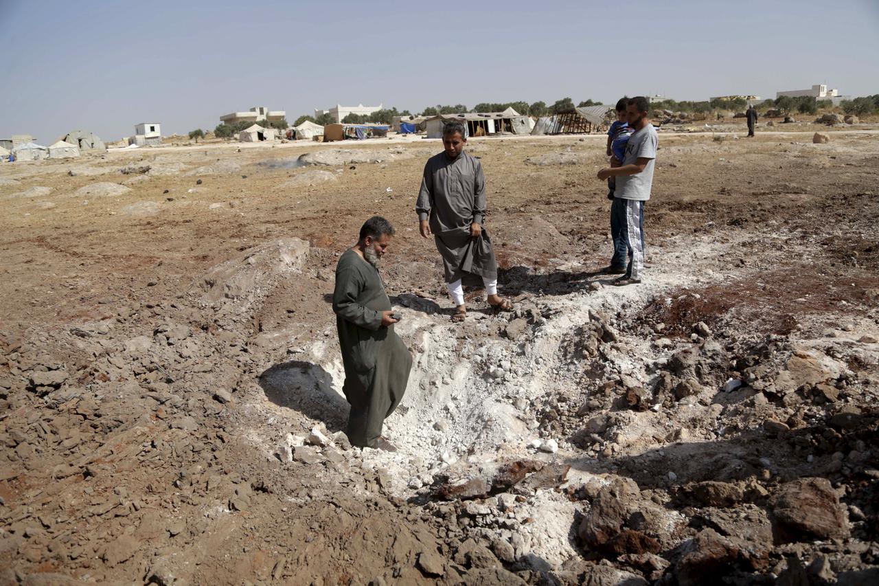 Men inspect a site hit overnight by what activists said were airstrikes carried out by the Russian air force near a camp for displaced people on the outskirts of al-Ghadfa town, in the southern countryside of Idlib, Syria, October 3, 2015. REUTERS/Khalil 