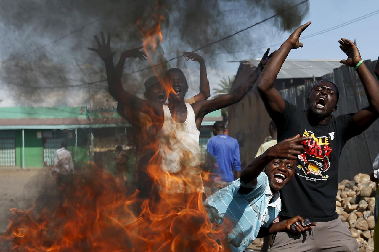 Protesters, who are against President Pierre Nkurunziza's decision to run for a third term, gesture in front of a burning barricade in Bujumbura, Burundi May 14, 2015. The head of Burundi's army said on Thursday that an attempted coup had failed and force
