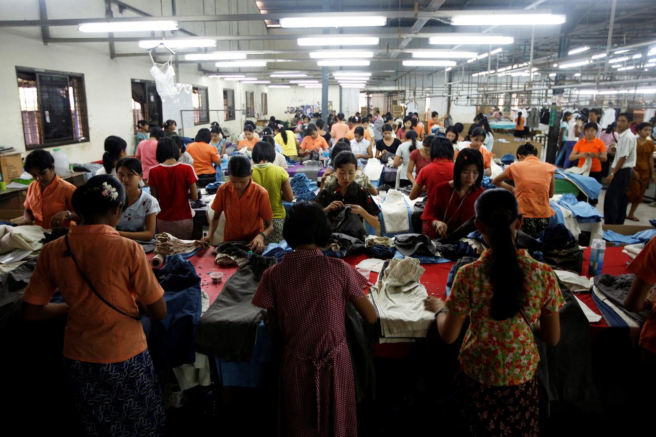FILE PHOTO: Workers tailor and arrange clothing at a garment factory at Hlaing Tar Yar industry zone in Yangon