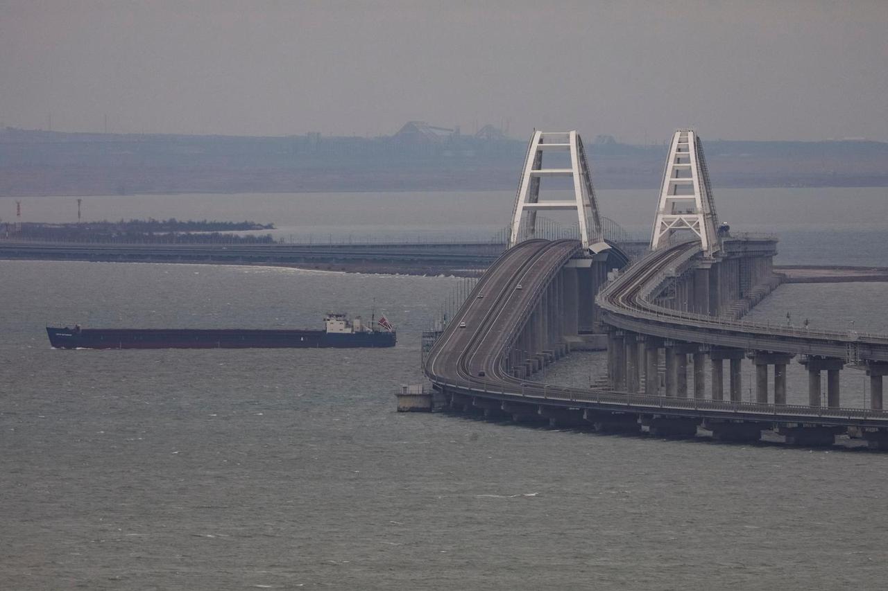 A cargo ship sails next to the Crimea bridge in the Kerch Strait