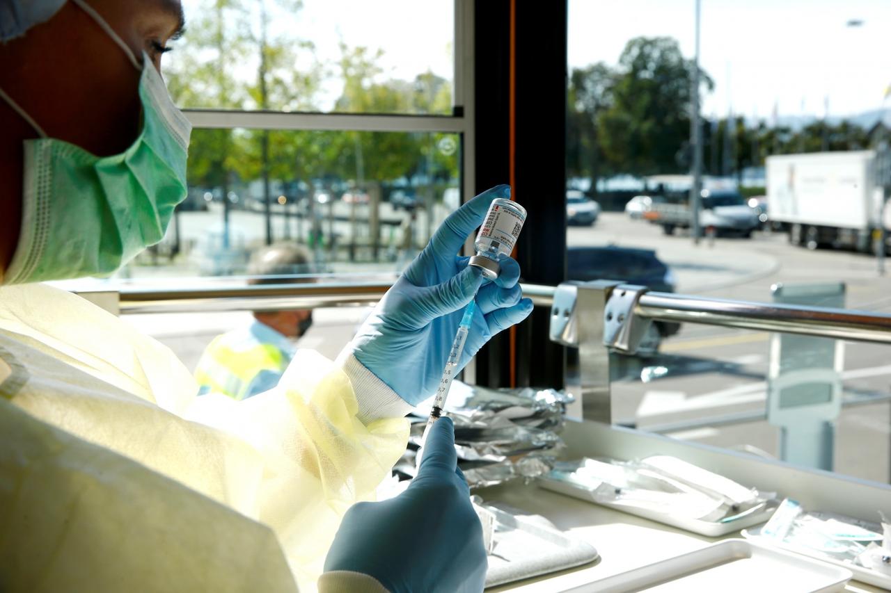 A health worker draws COVID-19 vaccine into a syringe inside the COVID-19 Impftram vaccination tram in Zurich