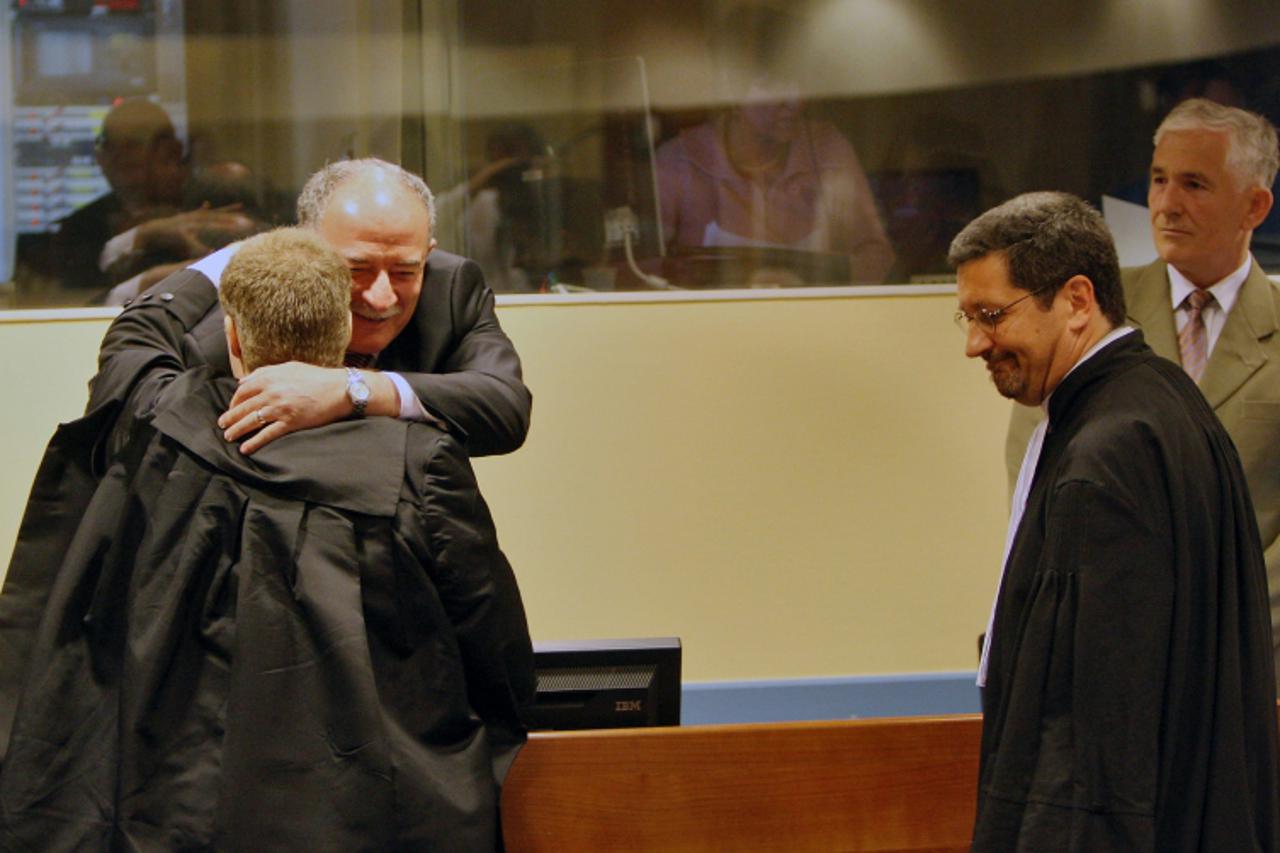 'Serbian Veselin Sljivancan, major in the former Yugoslav People\'s Army (JNA) (2ndL) embraces his lawyer before his verdict under the look of former JNA colonel Mile Mrksic (R) at the UN court for fo