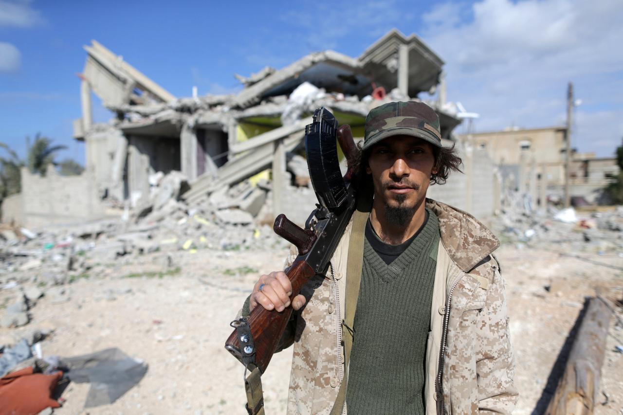 Member of East Libyan forces holds his weapon as he stands in front of a destroyed house in Ganfouda district in Benghazi A member of East Libyan forces holds his weapon as he stands in front of a destroyed house in Ganfouda district in Benghazi, Libya, J