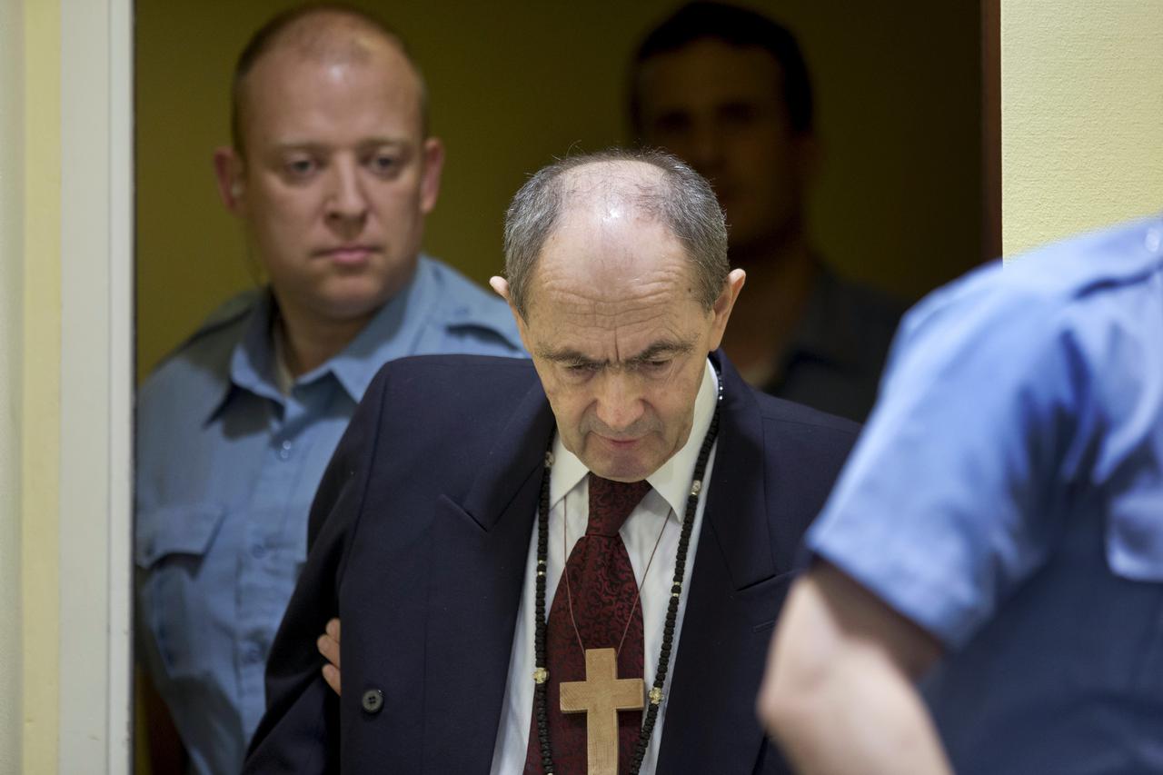 Zdravko Tolimir, a Bosnian Serb general convicted of genocide in the 1995 Srebrenica massacre, is escorted by U.N. security guards as he arrives in the courtroom of the the Yugoslav war crimes tribunal who delivered its judgment in his appeal case in The 