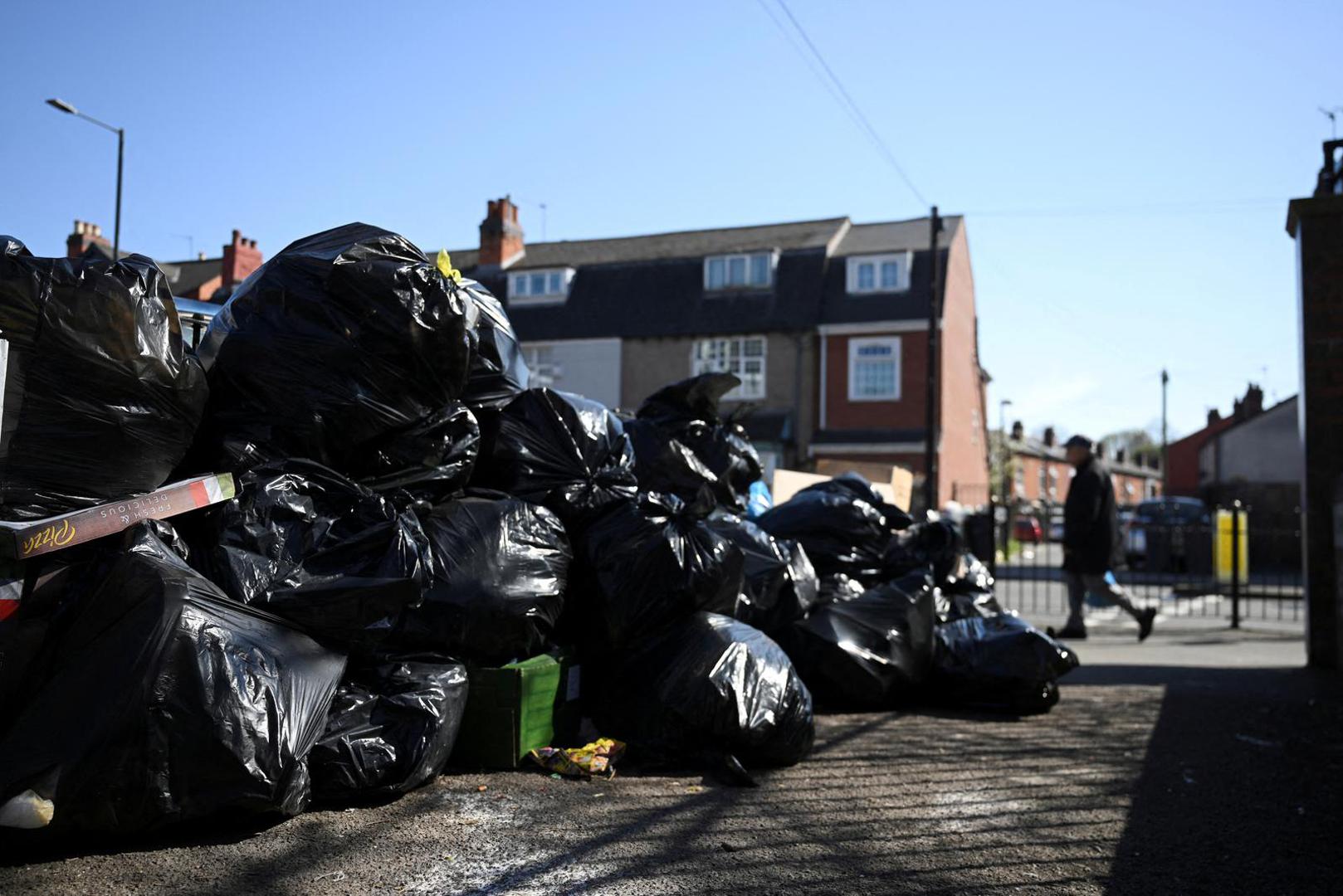 FILE PHOTO: A man walks past a pile of rubbish on the street, as the strike action by Birmingham bin workers represented by the Unite union enters its fourth week, in Sparkbrook, Birmingham, Britain, April 2, 2025. REUTERS/Jaimi Joy/File Photo Photo: JAIMI JOY/REUTERS