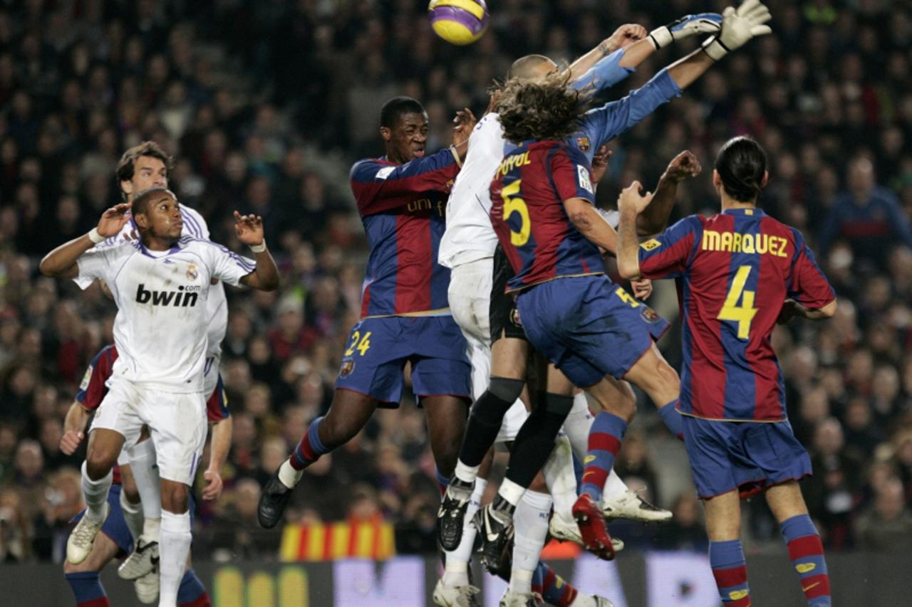'Real Madrid\'s Sergio Ramos (obscured, C) jumps for the ball against Barcelona\'s goalkeeper Victor Valdes during their Spanish first division soccer match at Nou Camp in Barcelona December 23, 2007 