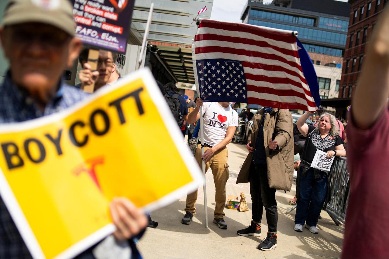 People protest against Tesla and its CEO Elon Musk outside a Tesla store in New York