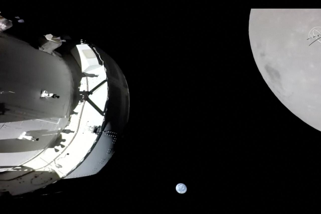 Camera on Orion's solar array wing captures a view of the spacecraft, the Earth and the Moon