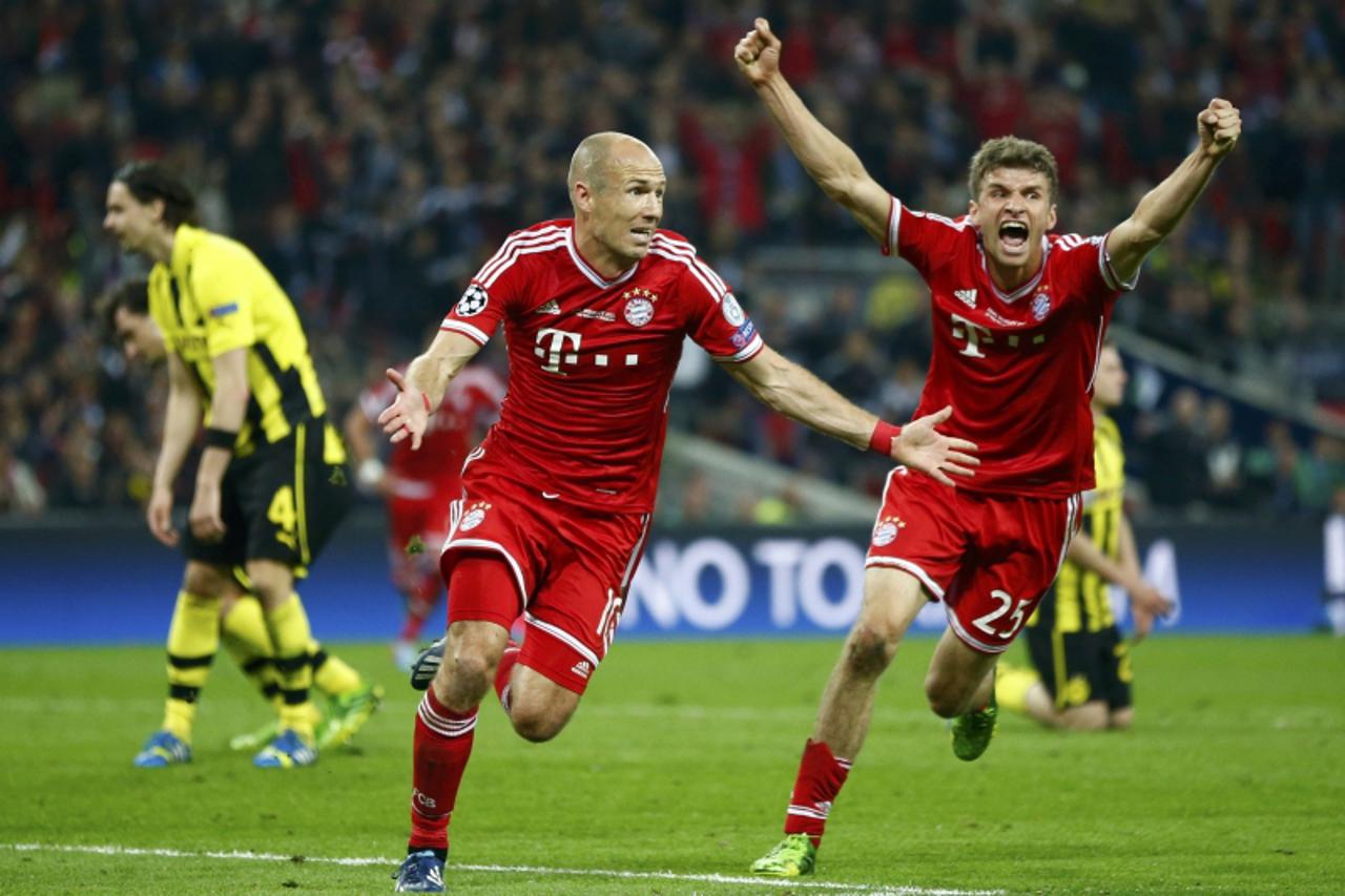 'Bayern Munich\'s Arjen Robben (C), flanked by team mate Thomas Mueller (R), celebrates after scoring the winning goal against Borussia Dortmund during their Champions League Final soccer match at Wem