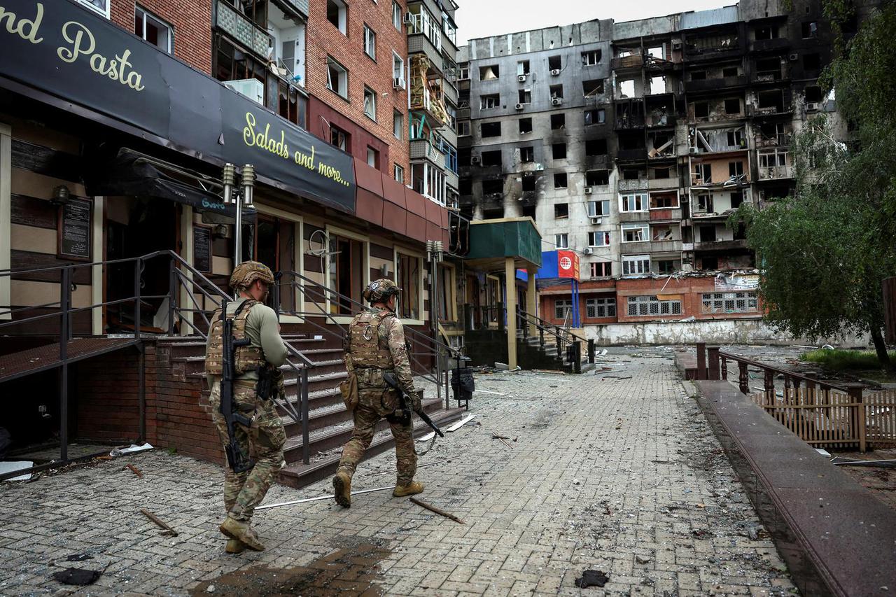 FILE PHOTO: Ukrainian police officers try to persuade residents to evacuate in the frontline town of Pokrovsk