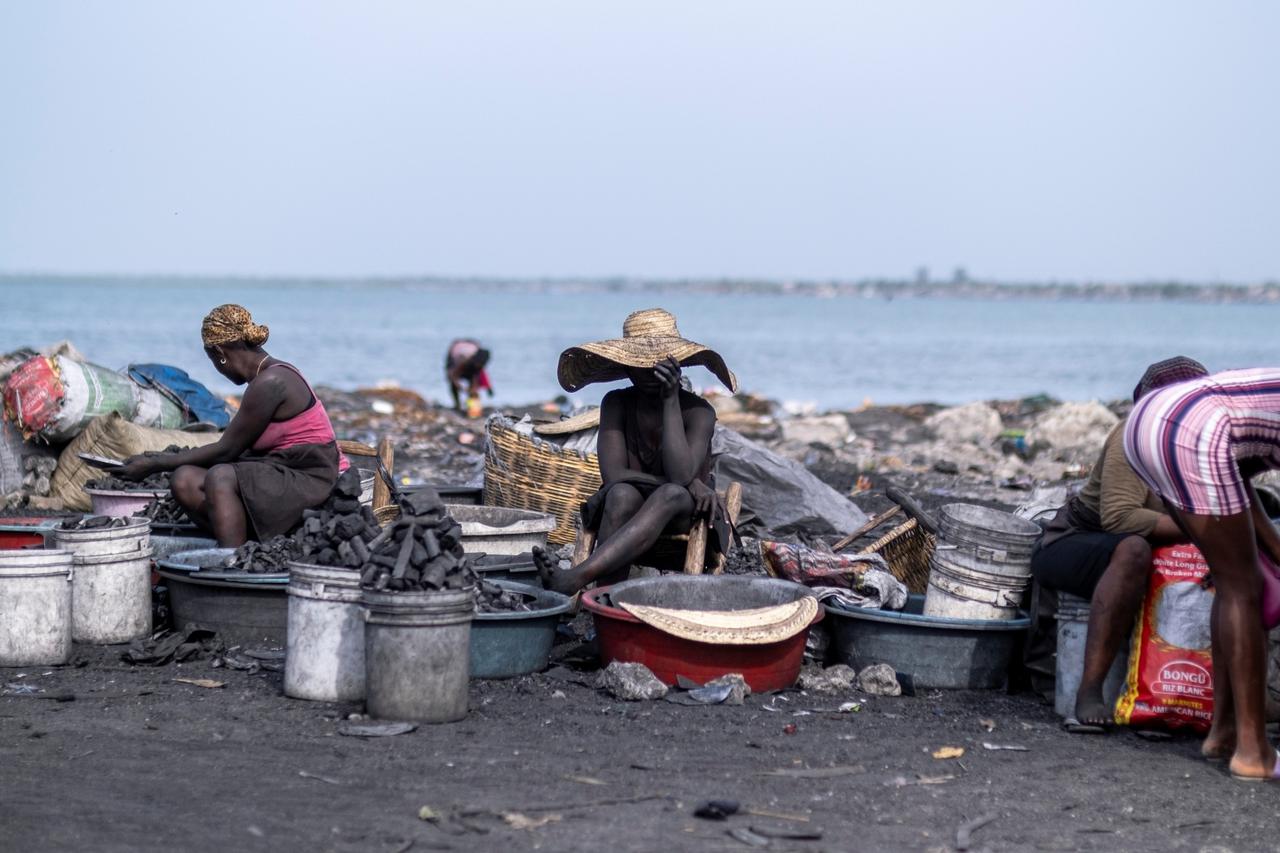 A charcoal street vendor sits at her post at a market in Cap-Haitien