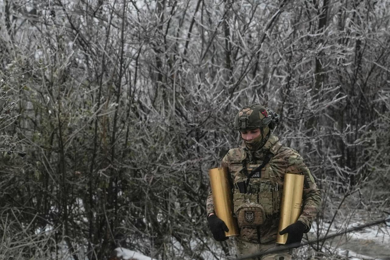 Ukrainian serviceman carries shells for a self-propelled howitzer at a position in a front line near the town of Bakhmut