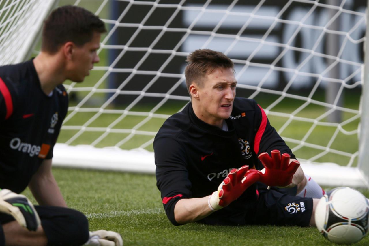 'Poland\'s national  goalkeepers Wojciech Szczesny (L) and Przemyslaw Tyton are seen during a practice session one day after their Euro 2012 opening soccer match in Warsaw June 9, 2012.  REUTERS/Kai P