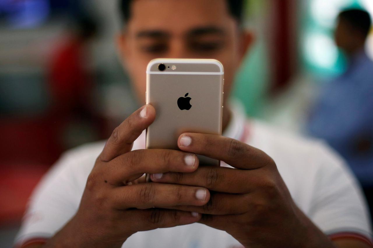 FILE PHOTO - A salesman checks a customer's iPhone at a mobile phone store in New Delhi FILE PHOTO - A salesman checks a customer's iPhone at a mobile phone store in New Delhi, India, July 27, 2016. REUTERS/Adnan Abidi/File photo ADNAN ABIDI