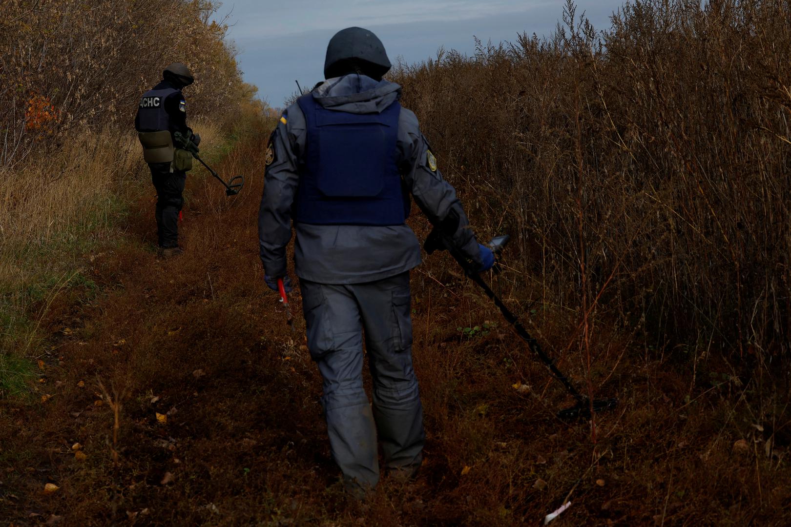 Firefighters Alexander and Maxim from the de-mining squad of the Ukrainian emergency services scan for land mines and other unexploded ordnance to clear an area for electricians to access electricity power lines damaged by Russian strikes in order to repair them safely, as Russia's invasion of Ukraine continues, in Ruska Lozova, Ukraine, October 25, 2022. REUTERS/Clodagh Kilcoyne Photo: Clodagh Kilcoyne/REUTERS