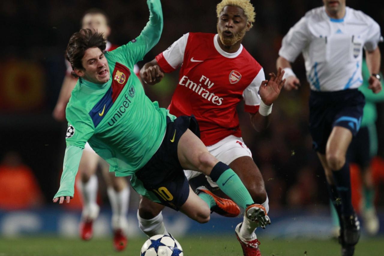 \'Alex Song of Arsenal tackles Lionel Messi of Barcelona during their Champions League soccer match at the Emirates stadium in north London, February 16, 2011. REUTERS/Eddie Keogh (BRITAIN - Tags: SPO