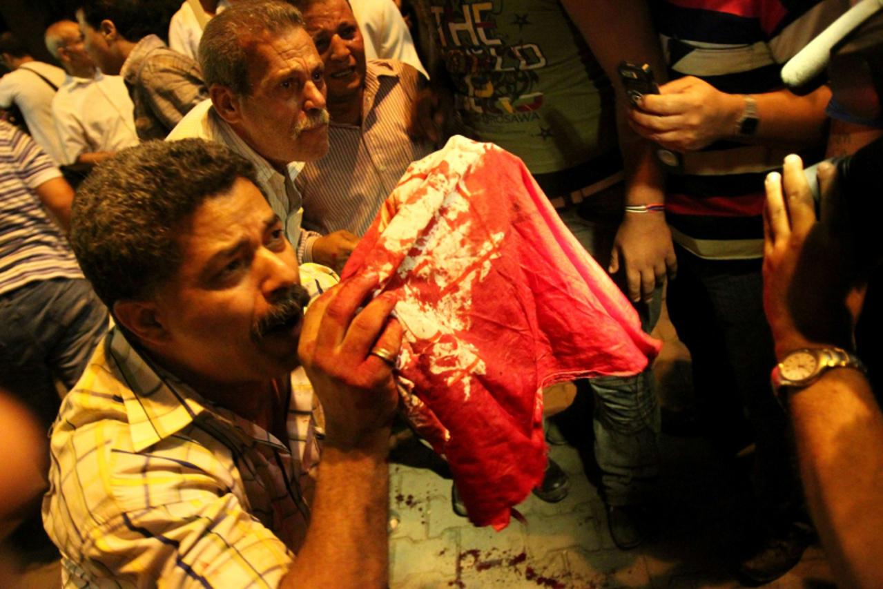 'Egyptian Coptic Christians hold up a blood streaked cloth after a clash with soldiers and anti-riot police during a protest in Cairo against the attack on a church in southern Egypt in October 9, 201