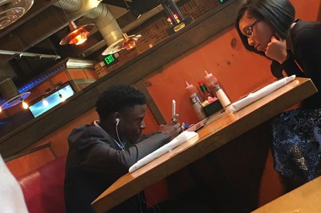 Par na spoju gleda u mobitel